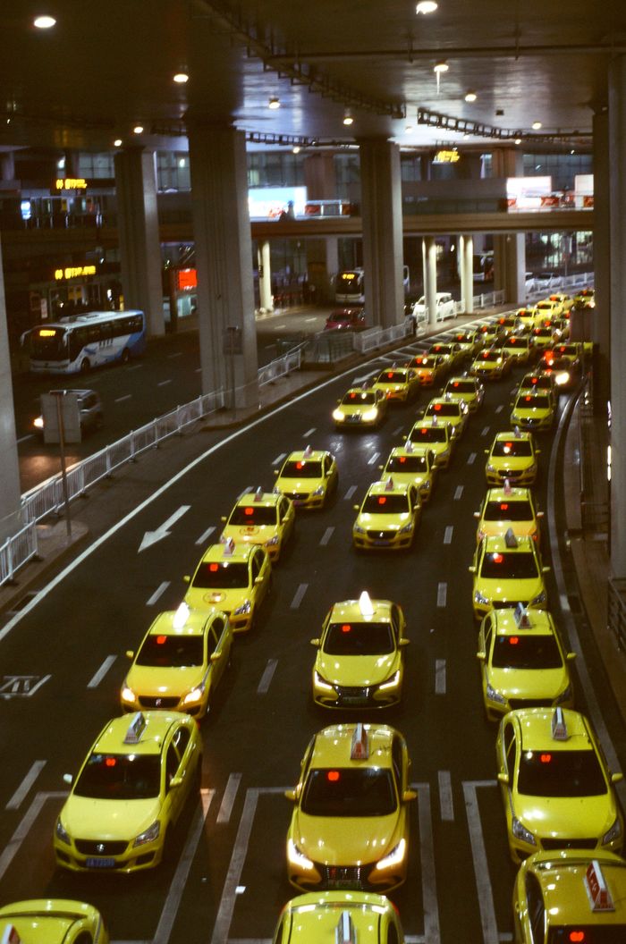 services-02 Aerial view of yellow taxis in an urban setting, showcasing a busy city traffic jam at night.